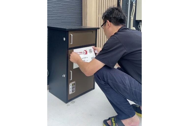 宅配ポストに案内を貼る部長